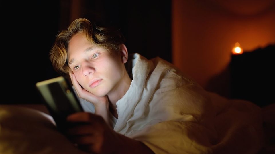 Is My Teen Anxious a teen boy anxiously scrolls his phone.