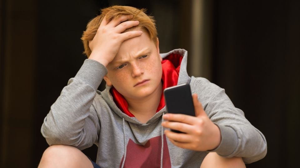 Symptoms of Being Roofied hero image of a teenage boy looking at his phone for the answer to the question.