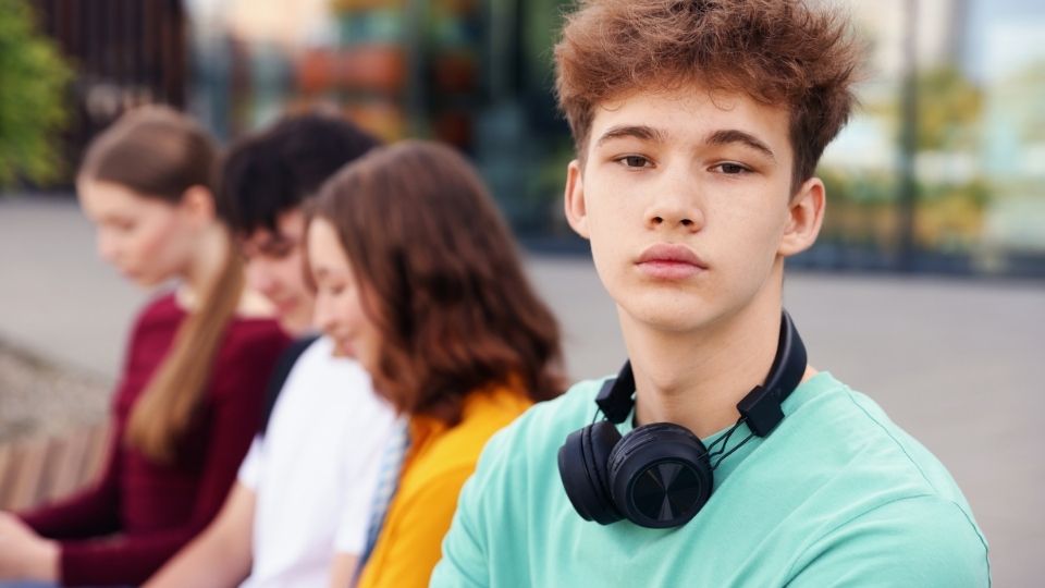 crossfaded hero image of a teen boy with friends wearing headphones.