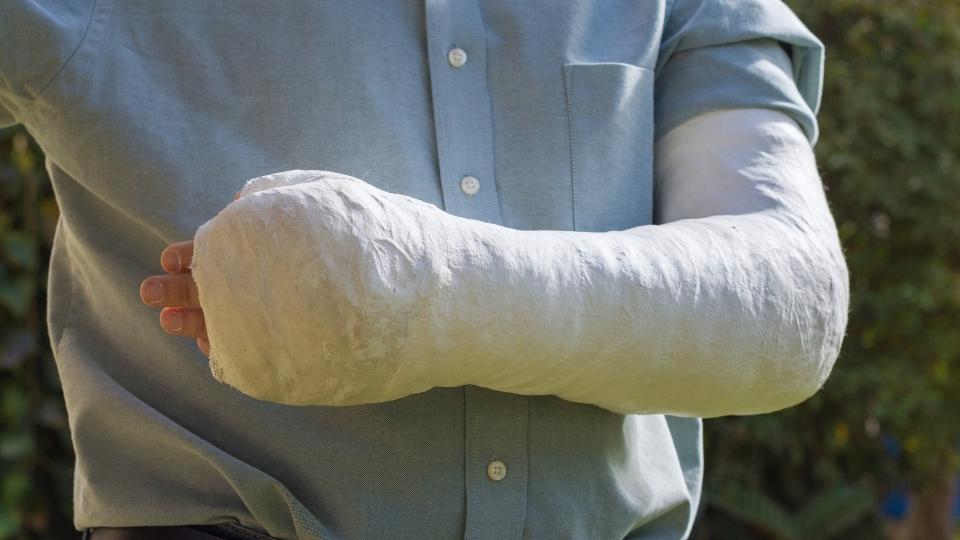A teen boy has a cast on his arm after an injury.