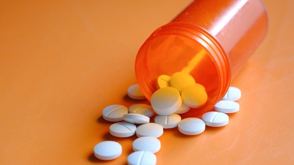 pressed pills spilling out of a pill bottle.